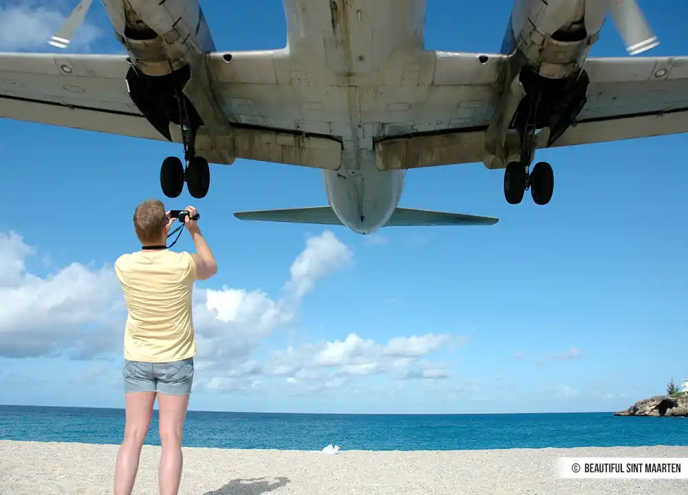 Vliegtuig over vliegt over strand Sint Maarten.